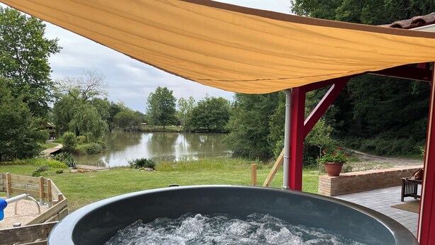 Un bain à remous avec vue sur un lac et la végétation environnante.