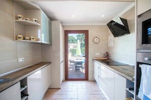 Enjoy cooking in this well-lit kitchen with an oven, sink, and microwave.