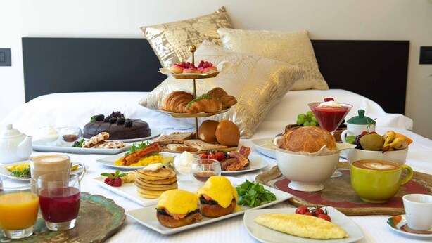 Un bufé de desayuno con diversos platos y bebidas sobre una mesa en una habitación de hotel.