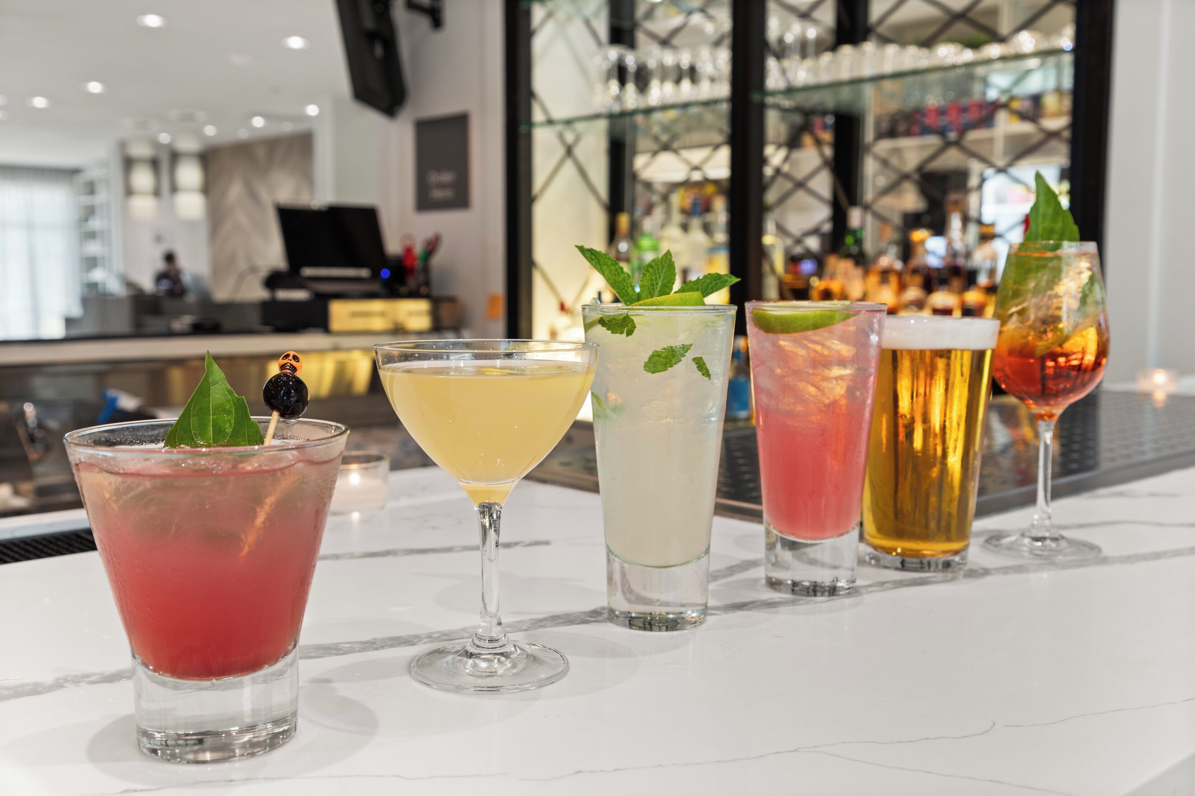 Zona de bar con diversas bebidas y una decoración moderna.