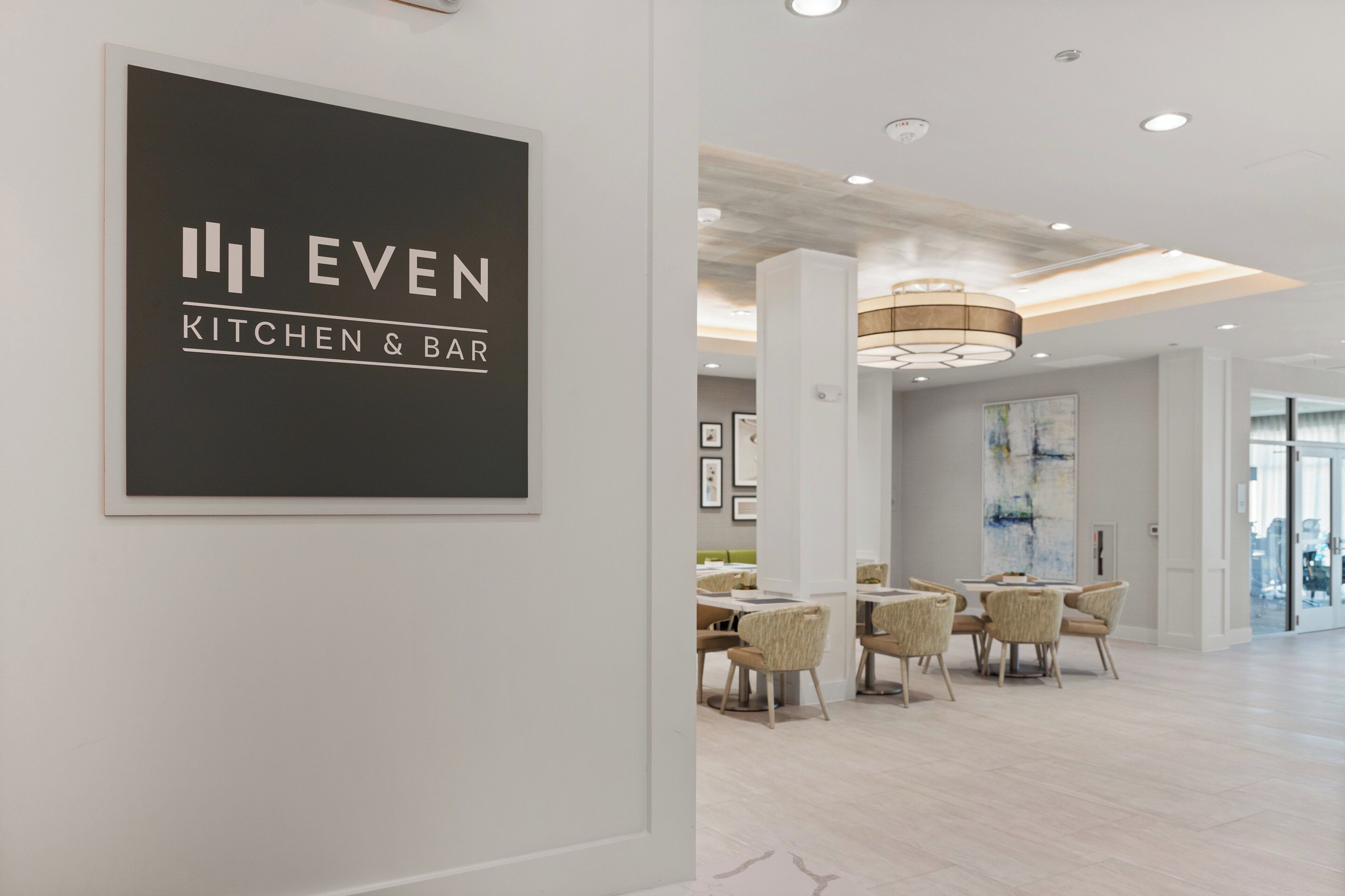Decoração moderna com um letreiro que diz 'EVEN KITCHEN & BAR'.