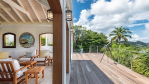 Una terraza de madera con mobiliario exterior y un telescopio.