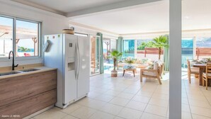Una cocina moderna con refrigerador empotrado, un lavamanos y una encimera de madera.