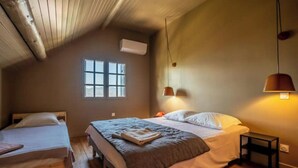 A bedroom with two beds, a window, and a ceiling fan.