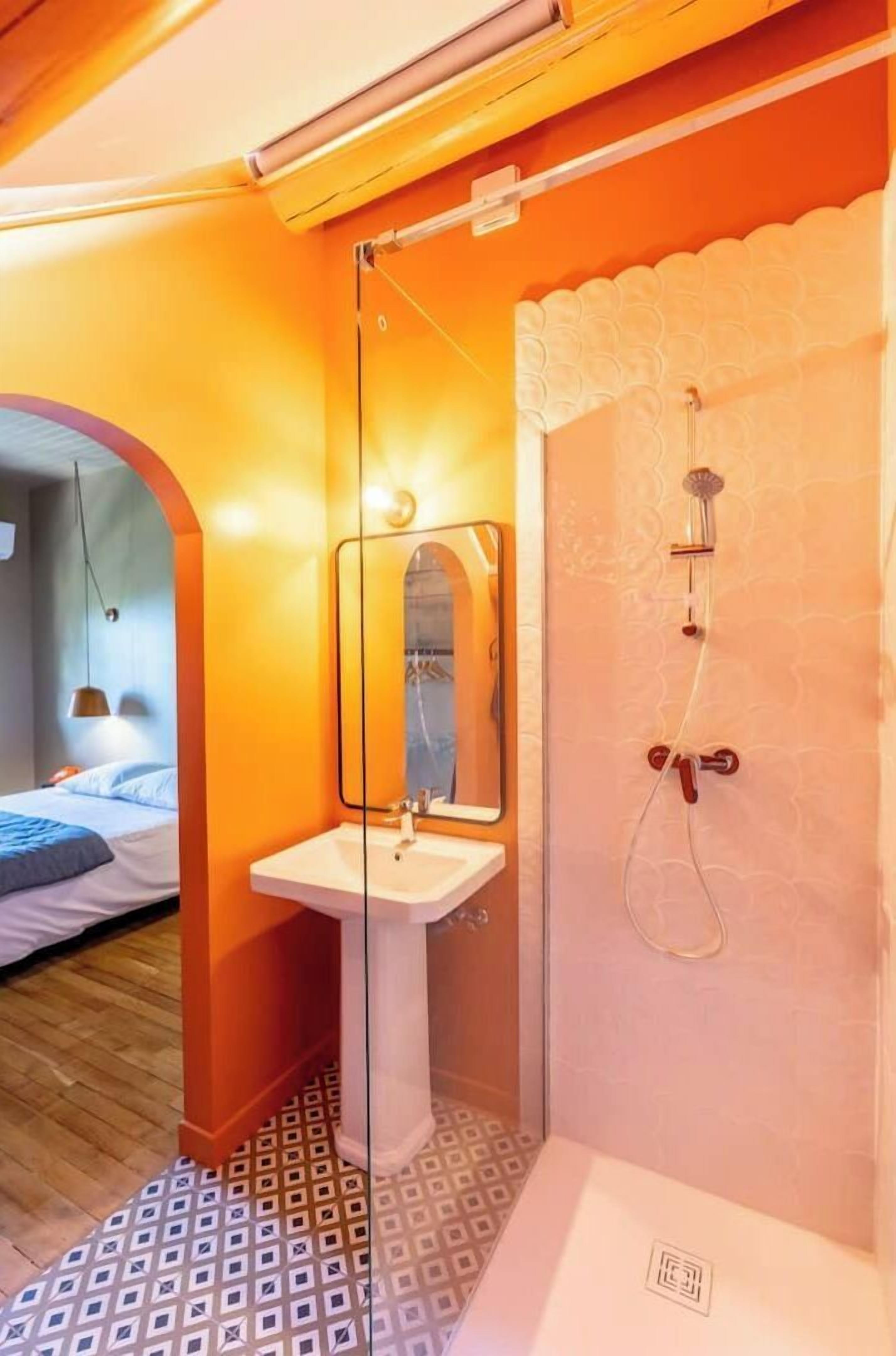 Un baño con cabina de ducha de vidrio, un lavabo y un espejo.