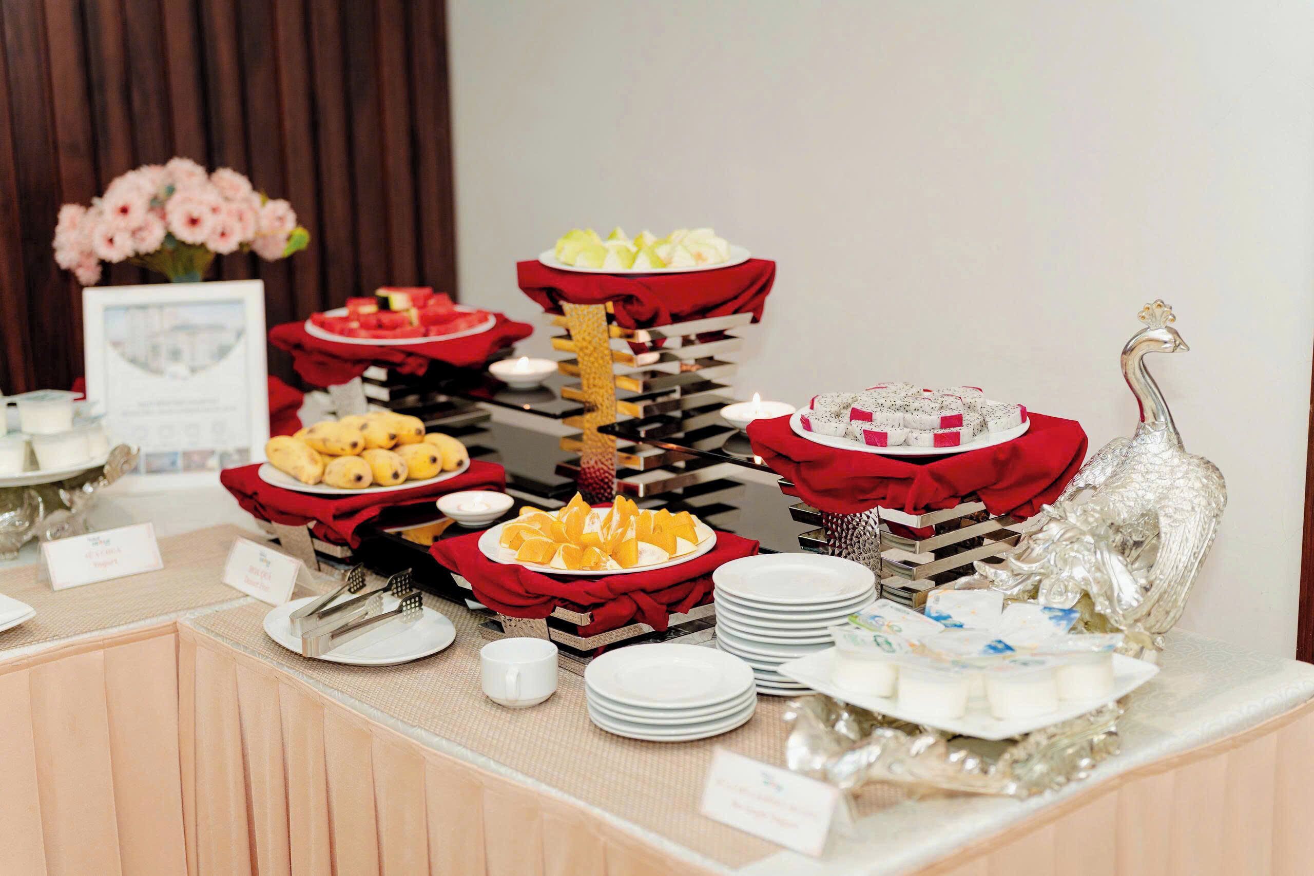 Une table de buffet garnie de divers plats et agrémentée d’un oiseau décoratif en argent.
