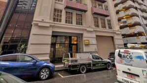 Un immeuble à plusieurs étages doté d’une entrée imposante, de grandes fenêtres et de balcons.