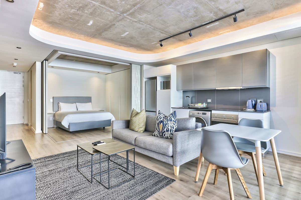 Un salon moderne avec un canapé, une table basse et un coin repas.