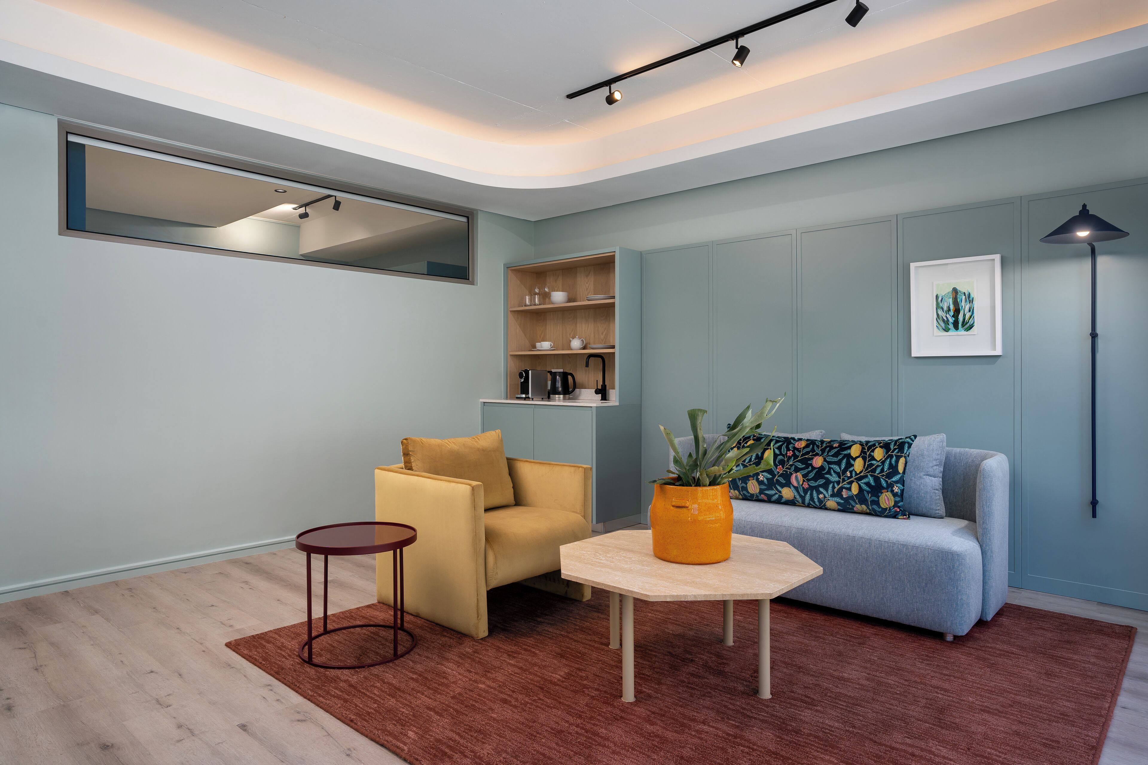 A modern living room with a sofa, armchair, coffee table, and a small side table.