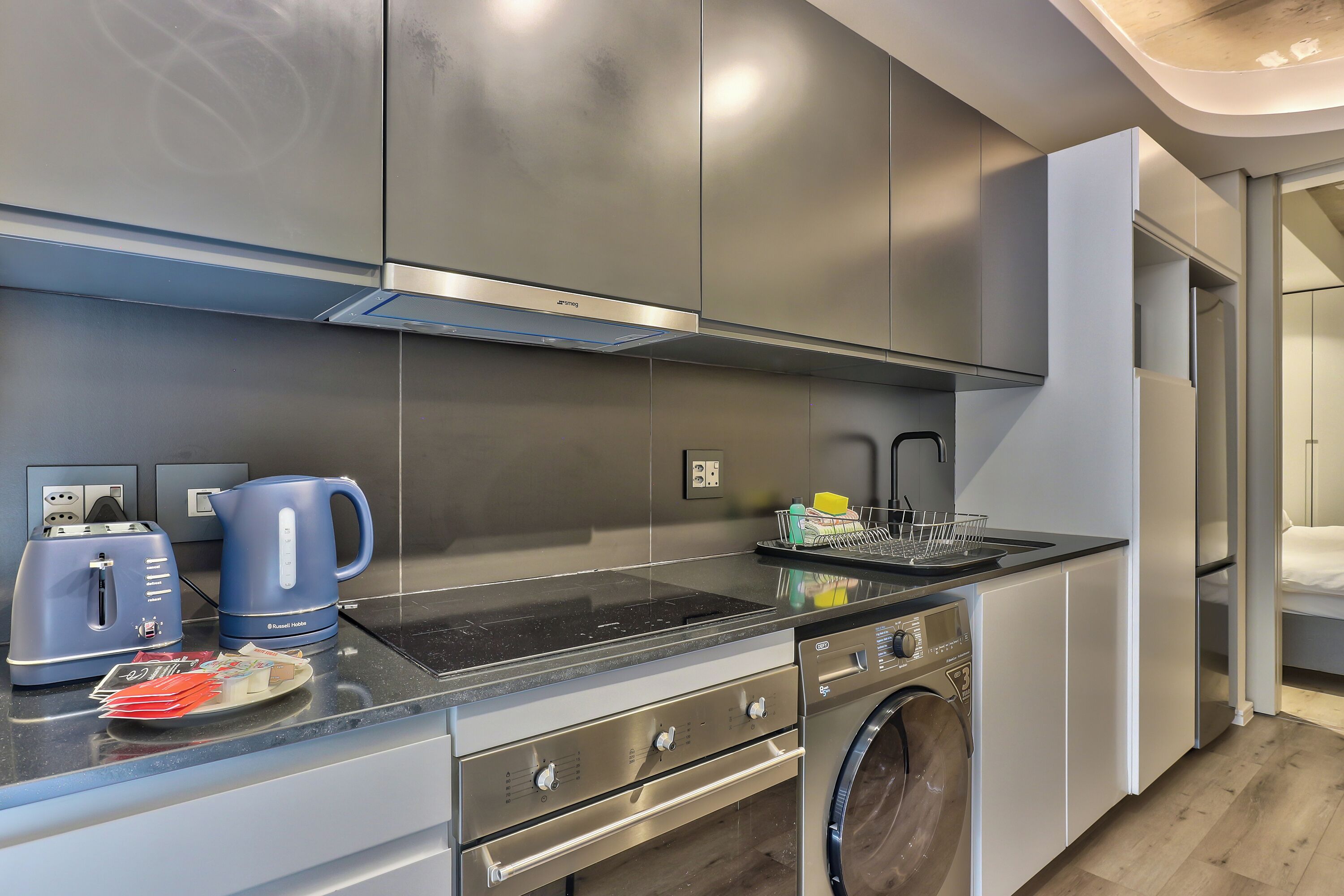 A modern kitchen with stainless steel appliances, a built-in oven, and a dishwasher.