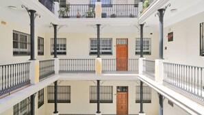 A multi-story building with balconies, railings, and doors.