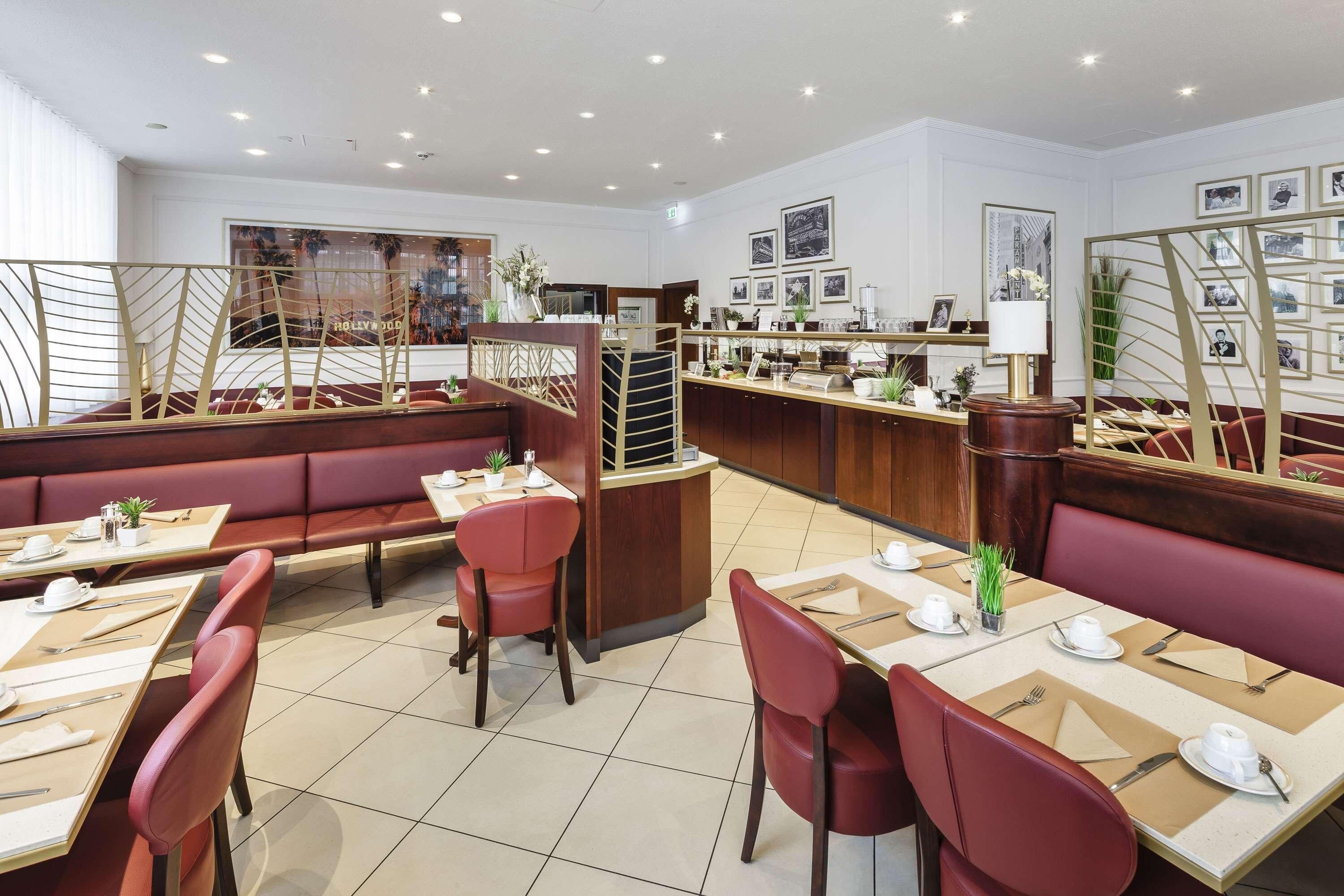 A modern restaurant with booths and tables, a bar area, and framed pictures on the walls.