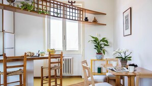 Une cuisine chaleureuse, avec des meubles en bois, une fenêtre et une plante posée sur le rebord de la fenêtre.