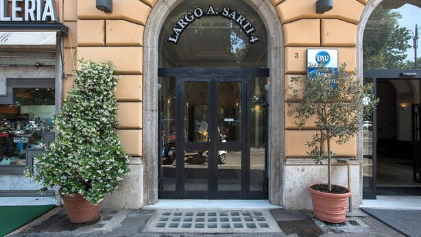 Une entrée d’immeuble avec une plaque indiquant « LARGO A. SARTIA ».