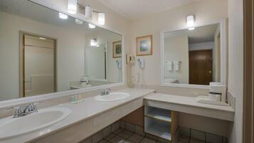 Une salle de bain avec deux lavabos, un miroir et des toilettes.