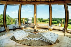 A spacious wooden deck with a view of a lush green landscape. - A magnificent eco-lodge in the heart of the Hautes-Pyrénées. (Senac)