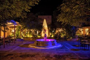 An outdoor area with a fountain, seating arrangements, and a well-lit environment. - Viva Azteca by Wyndham, A Trademark All Inclusive Resort (PLAYA DEL CARMEN)