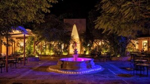 An outdoor area with a central fountain, surrounded by seating and greenery. - Viva Azteca by Wyndham, A Trademark All Inclusive Resort (PLAYA DEL CARMEN)
