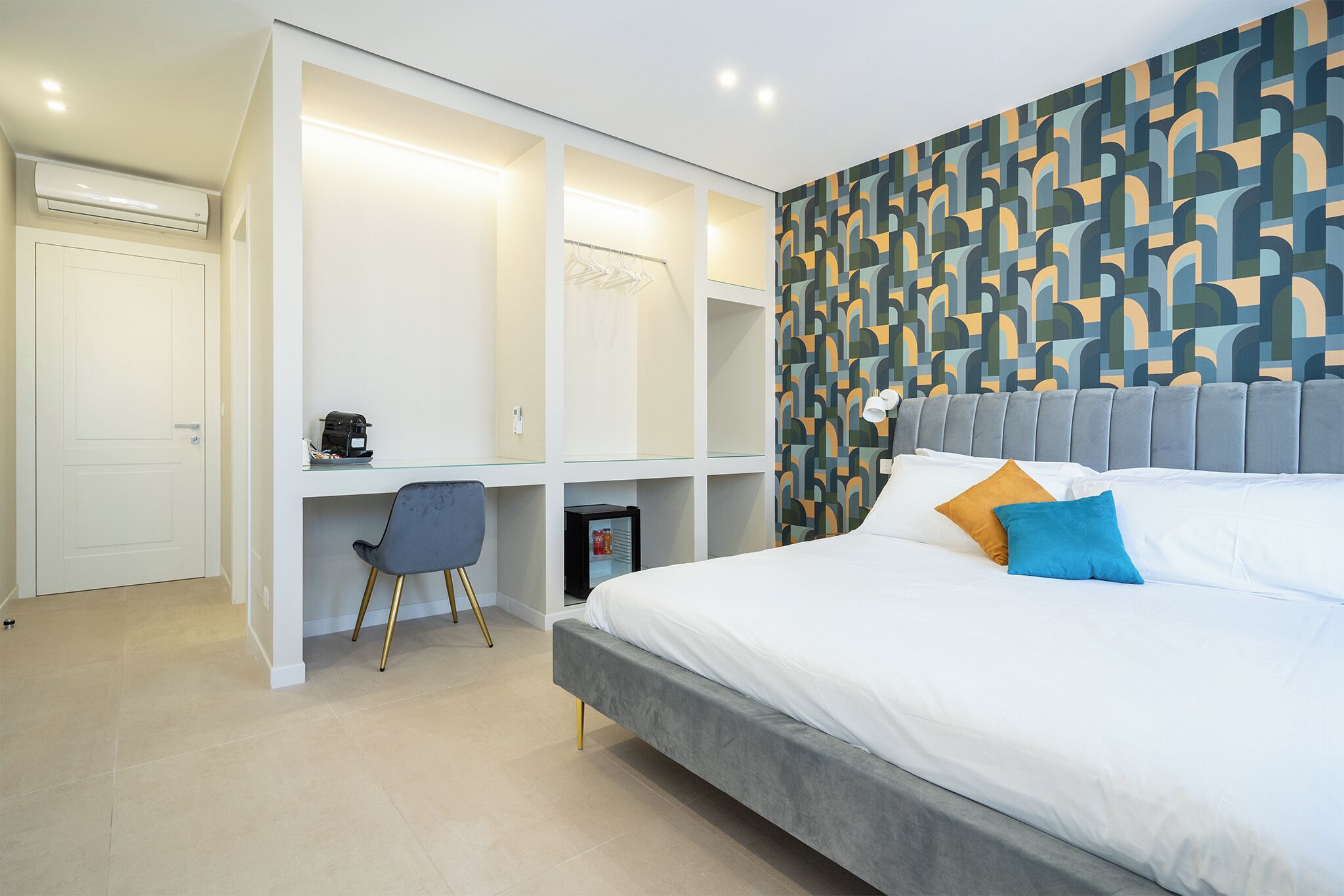 Een moderne slaapkamer met een bed, bureau en kledingkast.