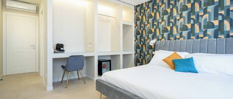 Een moderne slaapkamer met een bed, bureau en kledingkast.