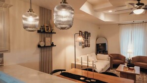 Une chambre d’hôtel moderne comprenant un coin repas, un ensemble de canapés et un téléviseur.