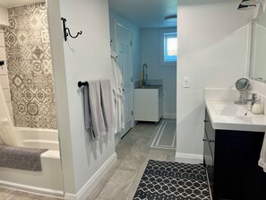 Une salle de bain avec une baignoire, un lavabo, un miroir et des carreaux décorés.