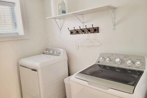 A laundry area with a front-loading washer and a top-loading dryer.