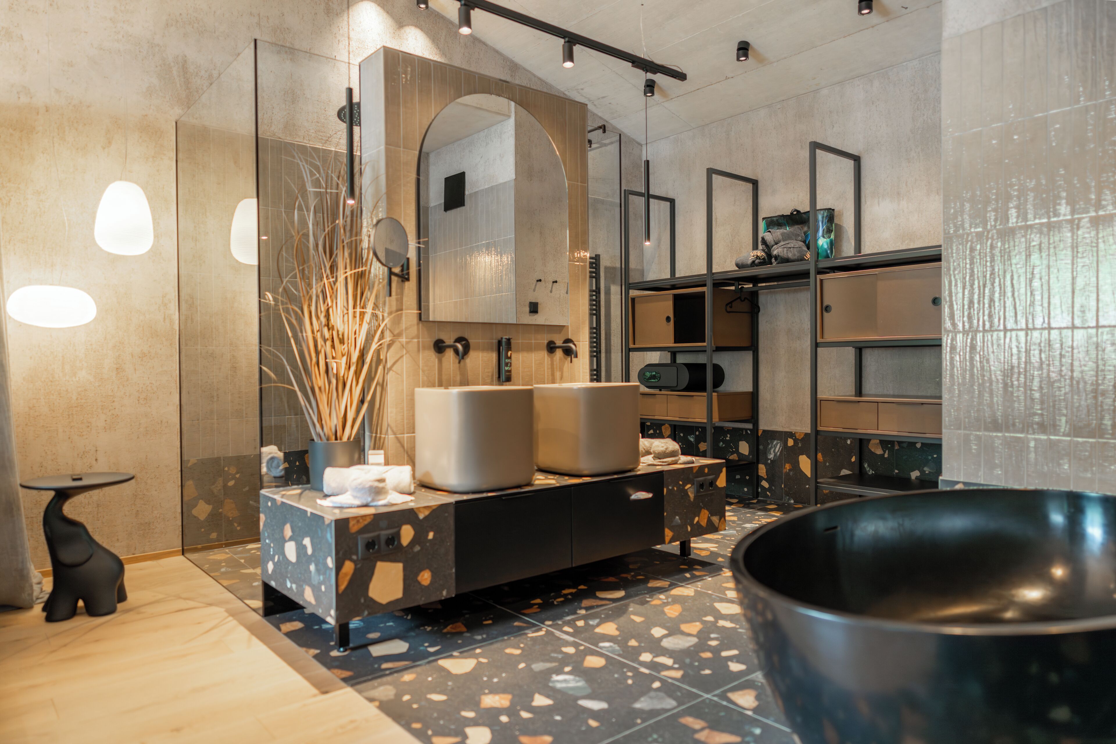 A modern bathroom with a freestanding bathtub, a large mirror, and a vanity with a sink and towel rack.