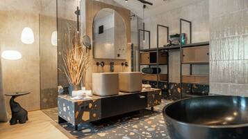 A modern bathroom with a freestanding bathtub, a large mirror, and a vanity with a sink and towel rack.