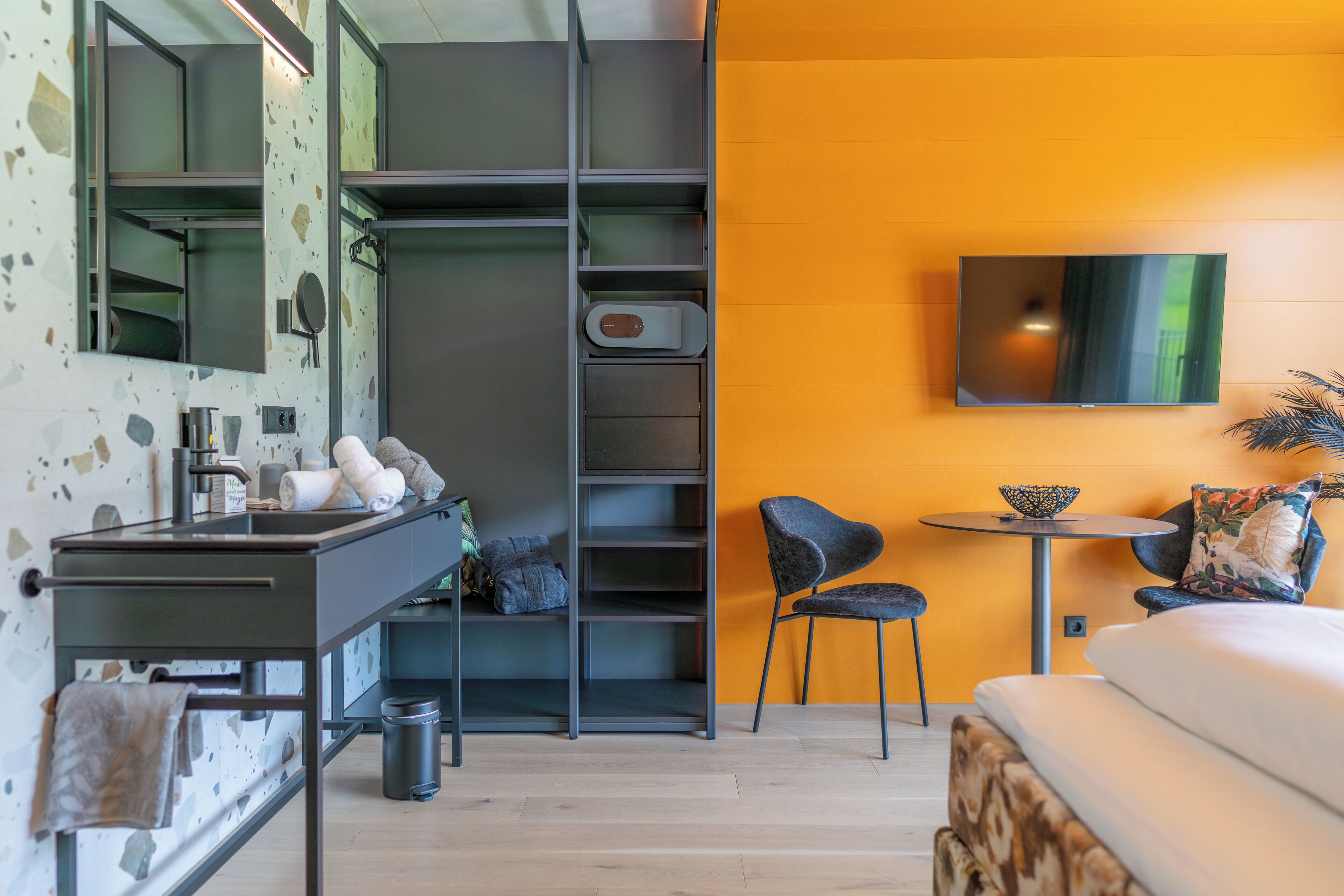 Une chambre moderne équipée d’une armoire intégrée, d’une petite table ronde, d’une chaise et d’un lit.
