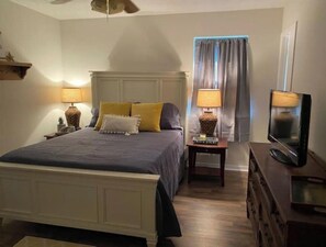 Cozy retreat with a large bed, two bedside tables, and a mounted television.