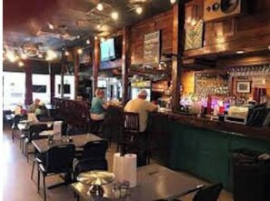 Enjoy a warm and inviting atmosphere in our rustic restaurant, where guests can sit at tables or the bar to enjoy a meal.