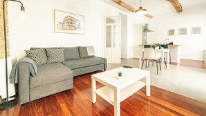 Un salon moderne avec un canapé gris, une table basse blanche et un plancher en bois.