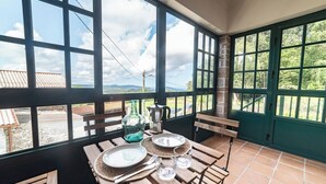 A terrace with a table set for two, overlooking a scenic landscape. - House O Carteiro "Cedeira". (Cedeira)
