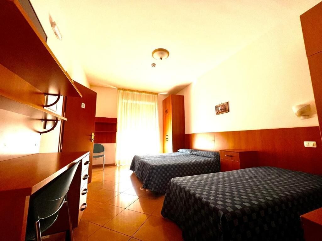 Una habitación de hotel con dos camas, un escritorio y una silla.