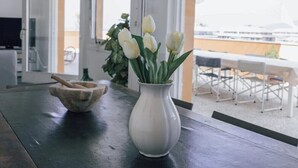 A modern kitchen with a dark countertop, a white vase with white flowers, and a rustic mortar and pestle. - [La terrazza di Chiavari] (Chiavari)