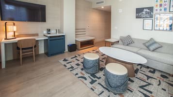 A modern living room with a sofa, coffee table, and a dining area with a chair and table.