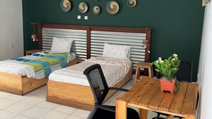 Une chambre avec deux lits en bois, une table à manger et une chaise.