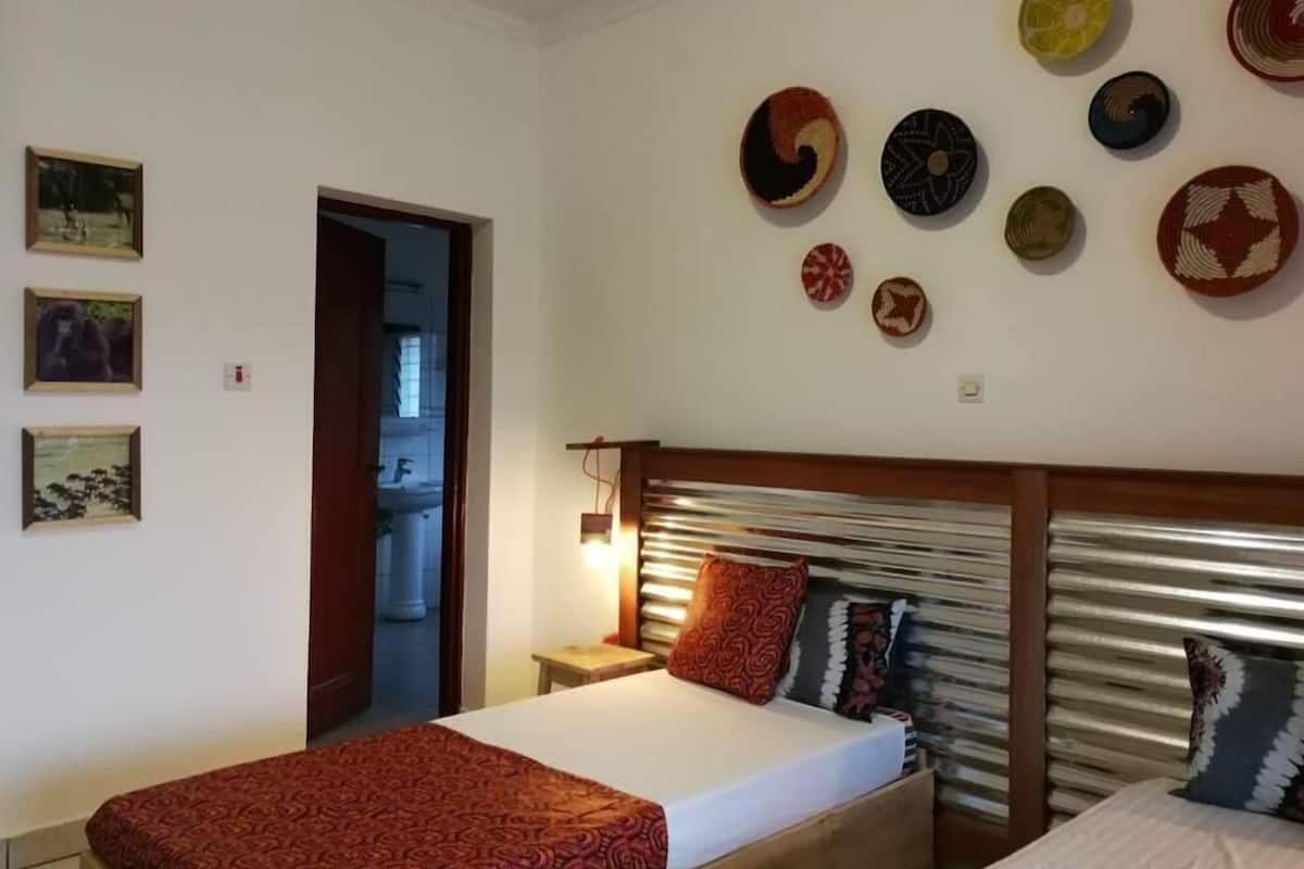Una habitación de hotel con una cama, una mesita de noche y un muro decorado con piezas de arte tejido circular.