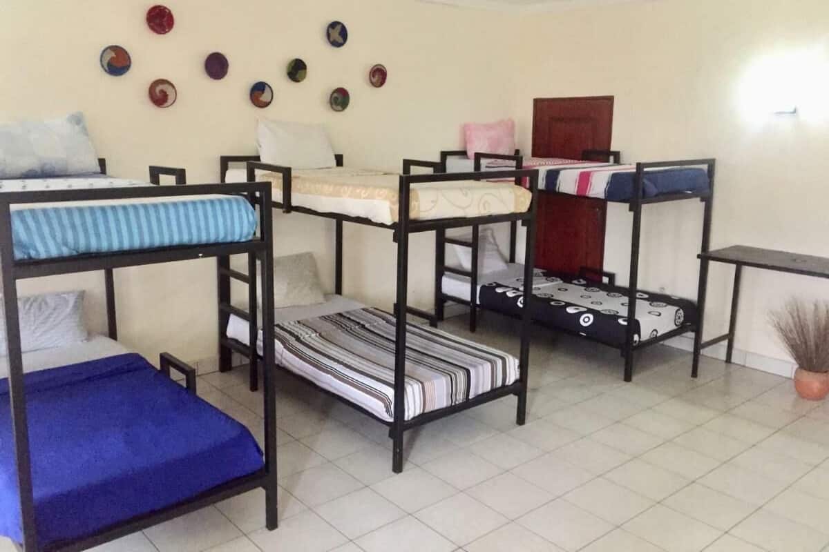 Un dormitorio con literas, piso de baldosas y adornos en la pared.