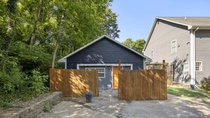 Ein Wohnhaus mit Garage, Holzzaun und Betonauffahrt.
