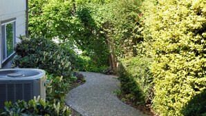 A pathway leading to a building surrounded by lush greenery. - ESCAPE TO WALLA WALLA WINE COUNTRY — YOUR PRIVATE KING SUITE ACROSS FROM TH... (College Place)