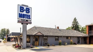A B&B motel with a large sign, a welcoming entrance, and a small porch area with potted plants. - The B&B Motel (Lewistown)