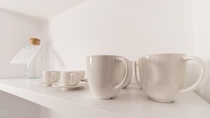A white shelf with three white cups and a small bottle. - Italianway Comfort - San Maurilio 20 B (Milan)