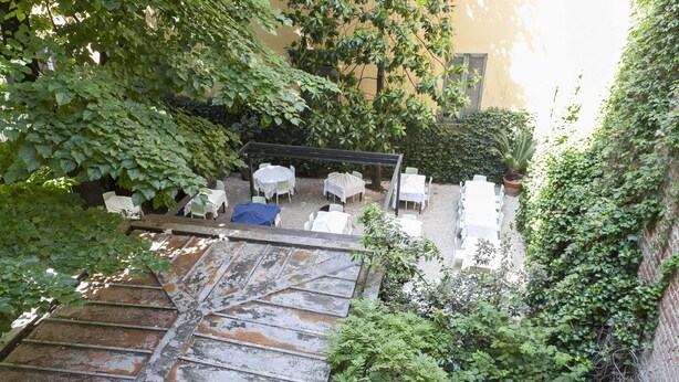Ein Innenhof mit Außenbestuhlung und einer Treppe.