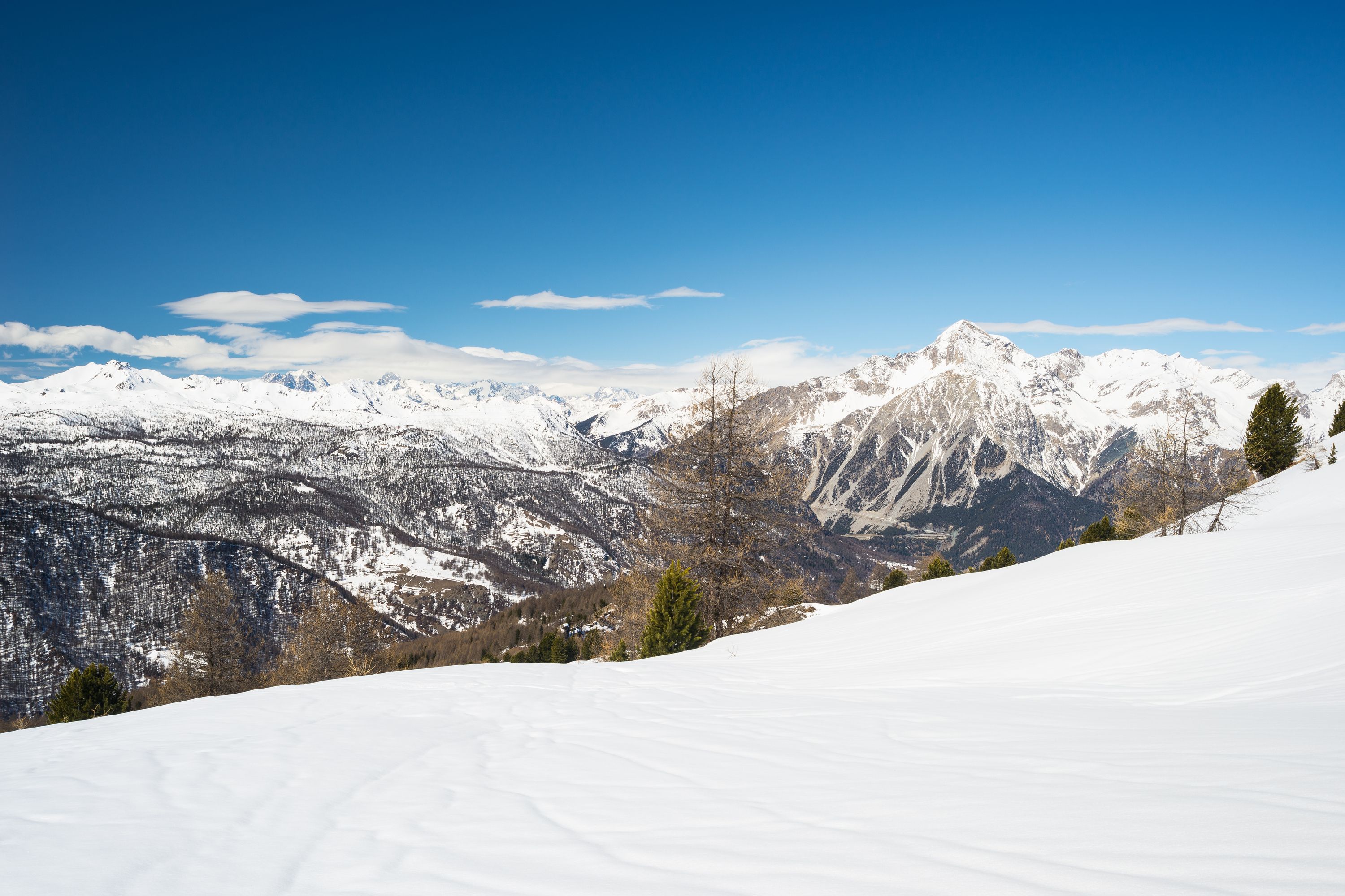 A snow-covered mountain landscape with clear skies.