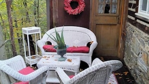 A cozy outdoor seating area with wicker furniture and a potted plant.