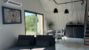 Un interno moderno con zona pranzo, cucina e un'ampia finestra.