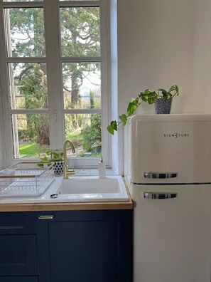 A kitchen with a window, sink, and a white appliance labeled "SIGNATURE".