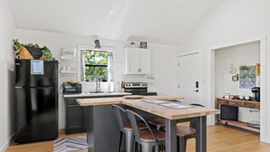 Een moderne keuken met een centraal eiland, een koelkast en een fornuis.